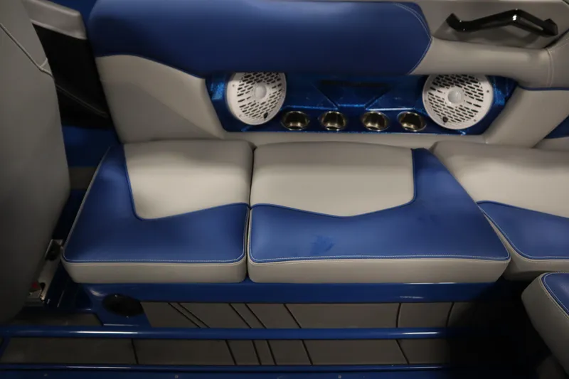 Slide: The Image of 2025 Centurion Fe23 interior with blue and gray seating, cup holders, and speakers. - 49