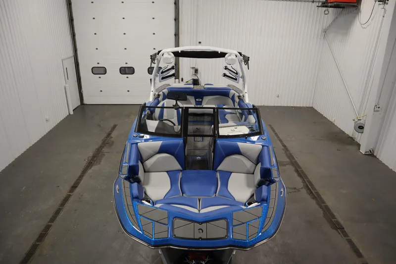 Slide: The Image of 2025 Centurion Fe23 boat with blue and gray interior in a garage setting. - 9