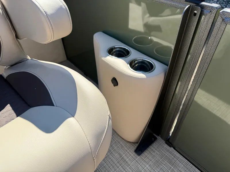 Slide: The Image of 2026 Bentley Pontoons Elite 220 Admiral interior with cup holders and beige seating. - 15