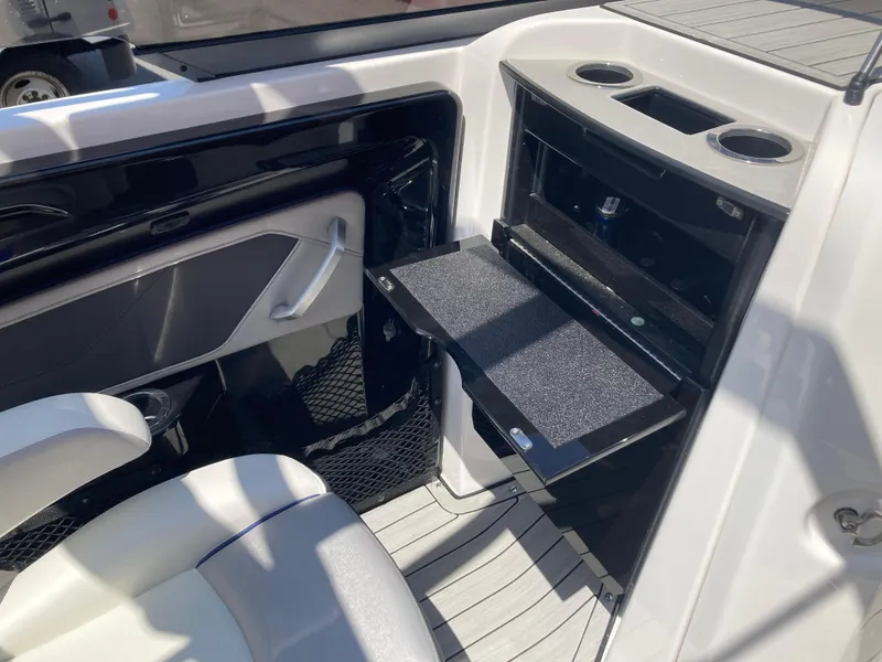Slide: The Image of 2021 Yamaha Boats 252S interior with storage compartment and cup holders. - 16