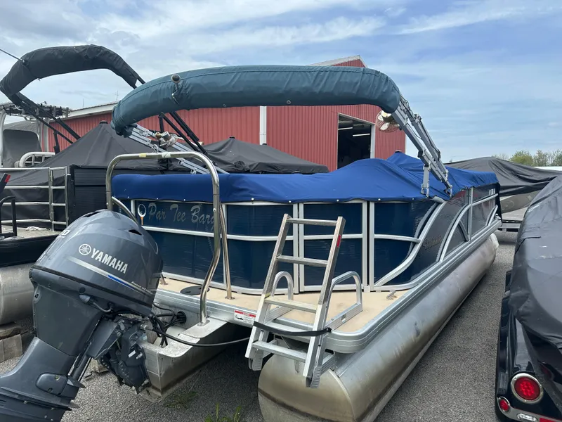 Slide: The Image of Pontoon boat Sweetwater Premium Edition 200, 2014 model, with Yamaha motor, docked outdoors. - 2