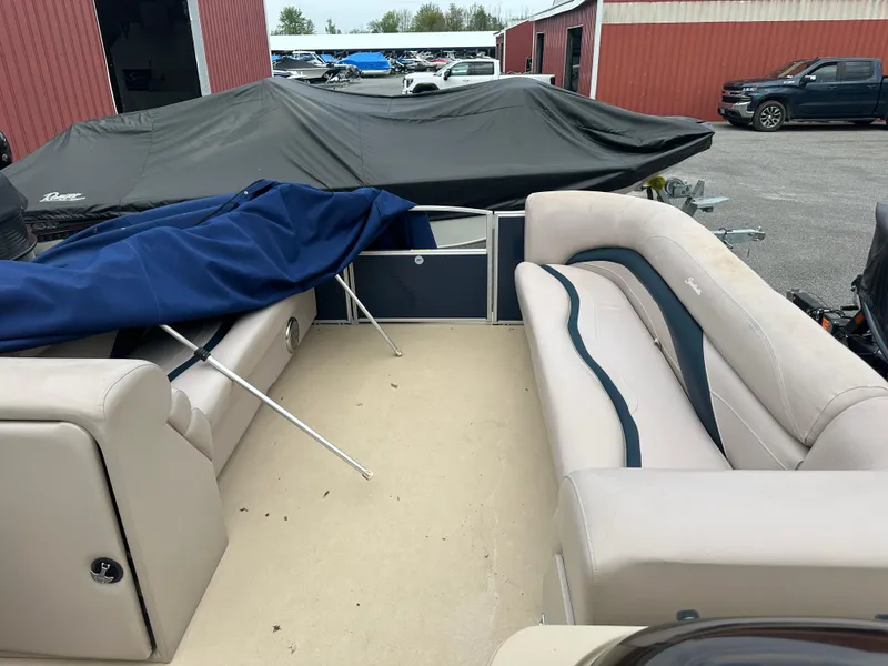 Slide: The Image of Interior of a 2014 Sweetwater Premium Edition 200 boat with beige seating and blue cover. - 6