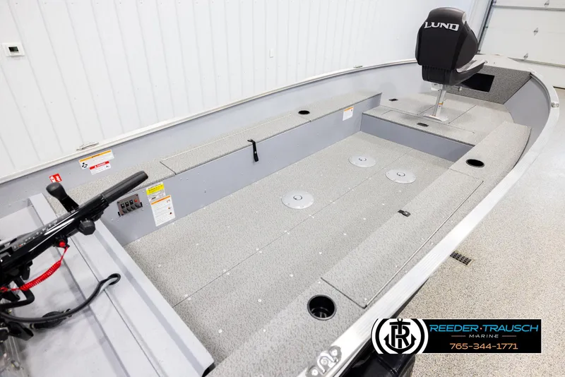 Slide: The Image of 2026 Lund 1600 Fury Tiller boat interior with seating and controls in a showroom. - 10