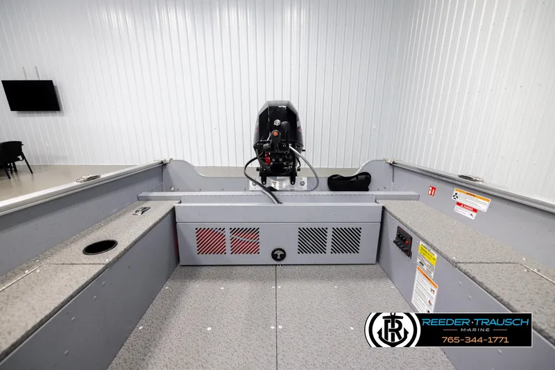 Slide: The Image of 2026 Lund 1600 Fury Tiller boat interior with motor, displayed in showroom. - 13