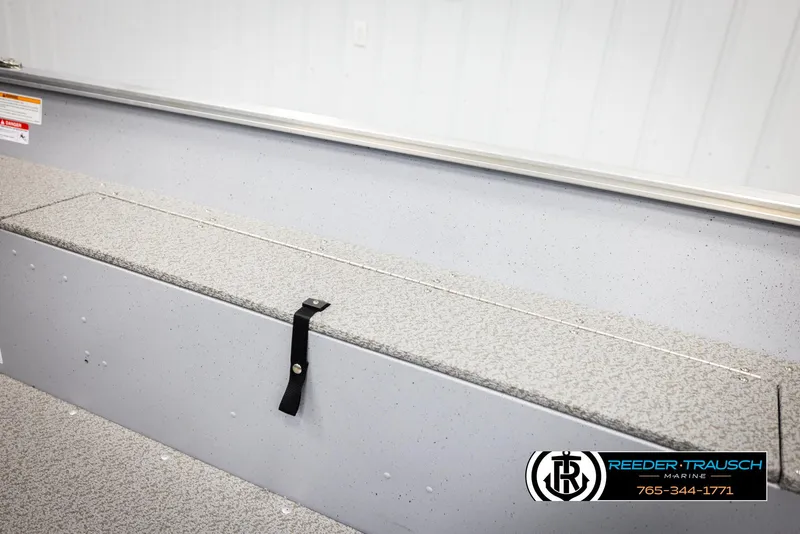 Slide: The Image of 2026 Lund 1600 Fury Tiller boat interior with storage compartment and safety strap. - 17