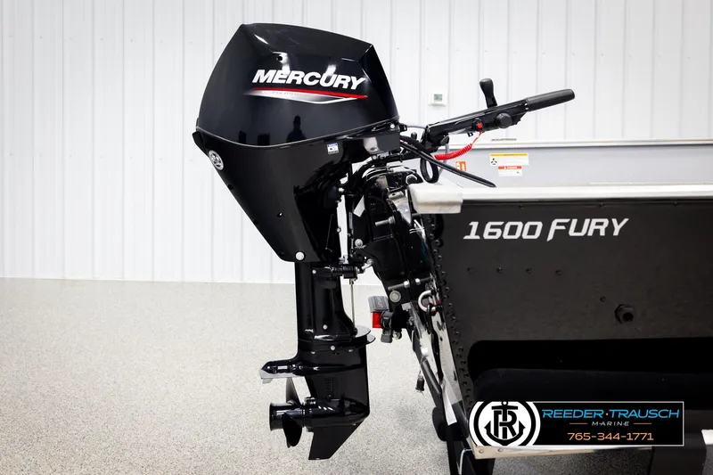 Slide: The Image of 2026 Lund 1600 Fury Tiller boat with Mercury outboard motor, displayed indoors. - 31