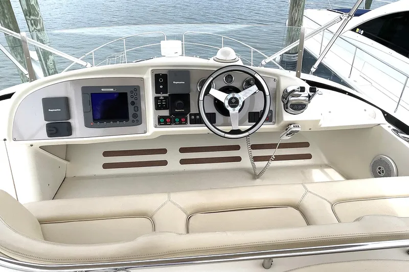 Slide: The Image of 2007 Prestige 46 Flybridge helm with steering wheel, navigation controls, and Raymarine equipment. - 18