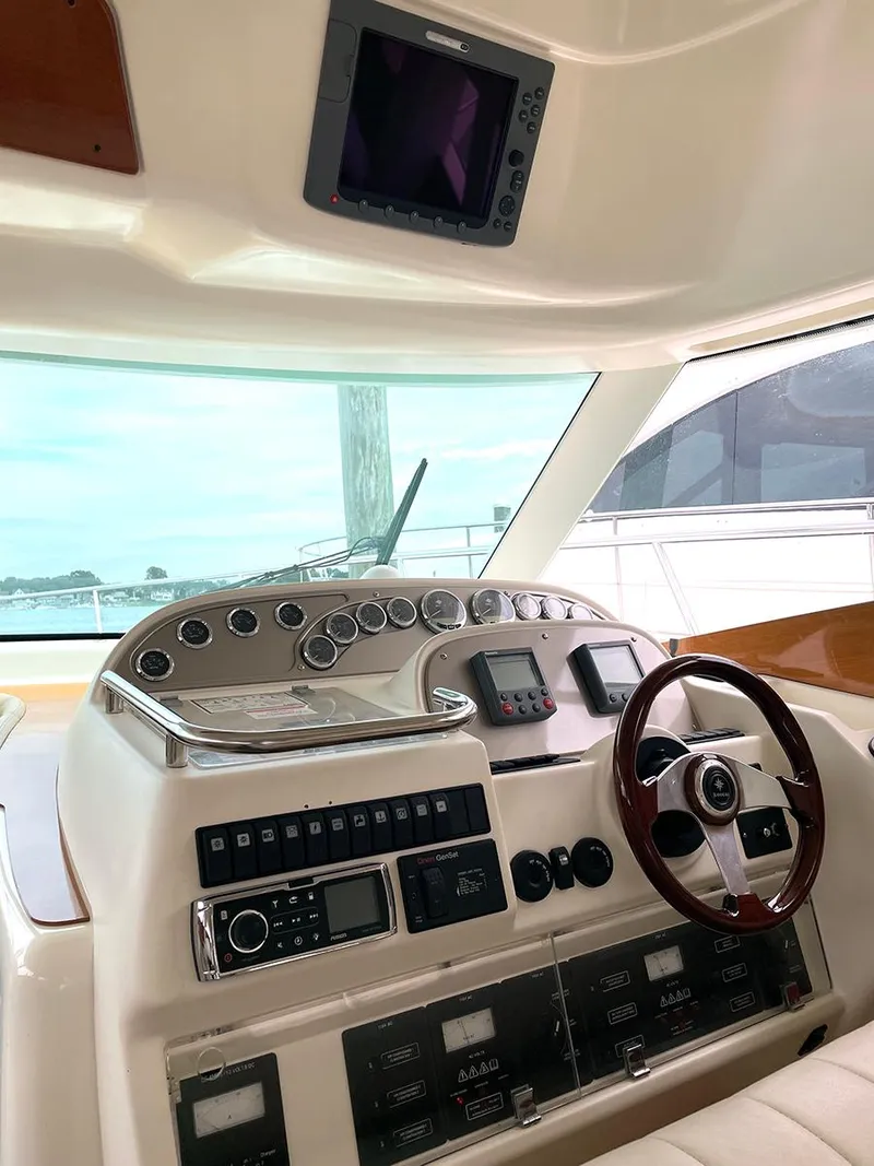 Slide: The Image of 2007 Prestige 46 Flybridge yacht helm with steering wheel and control panel. - 23