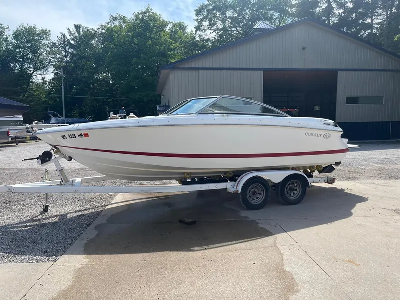 Slide: The Image of 2009 Cobalt 210 boat on trailer, parked outdoors near a building. - 10