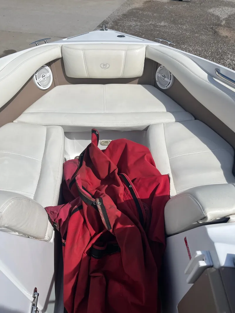 Slide: The Image of Interior of a 2009 Cobalt 210 boat with white seating and a red cover. - 7