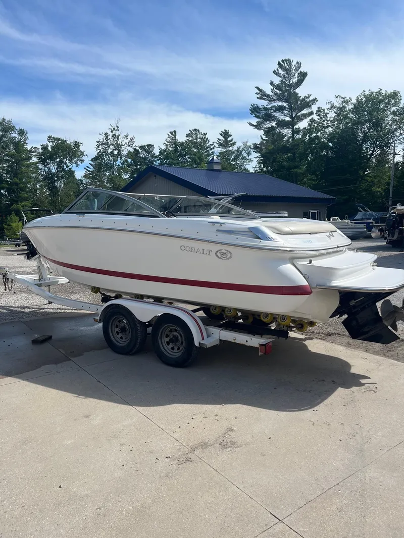 Slide: The Image of 2009 Cobalt 210 boat on trailer, parked outdoors under clear sky. - 9