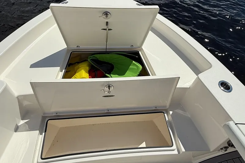 Slide: The Image of 2024 Pathfinder 2700 Open boat storage compartments with colorful gear inside. - 10