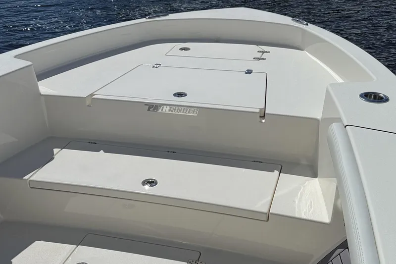 Slide: The Image of 2024 Pathfinder 2700 Open boat deck with storage compartments, on calm water. - 9
