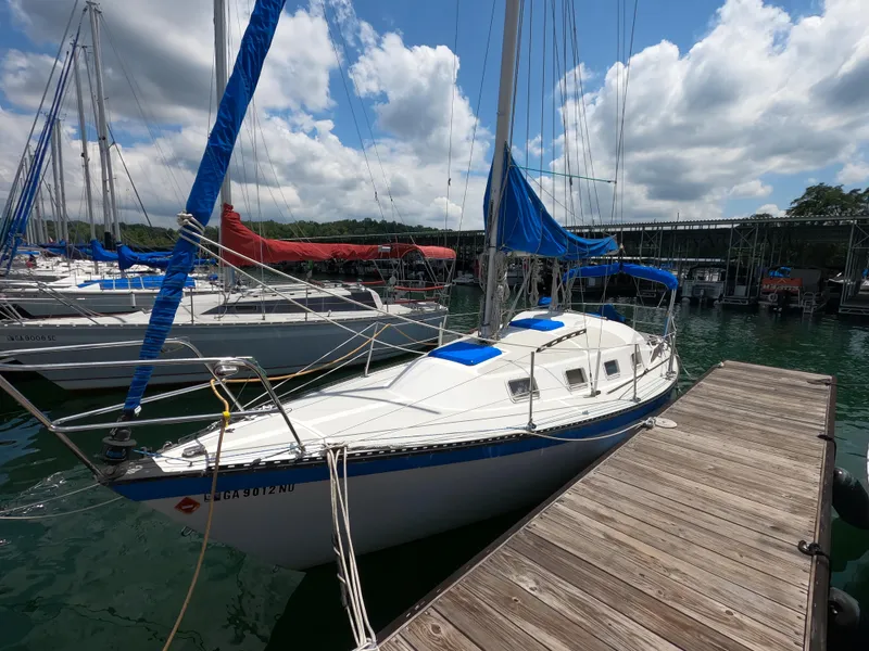 Slide: The Image of 1984 Lancer 30 sailboat docked at marina under partly cloudy sky. - 1