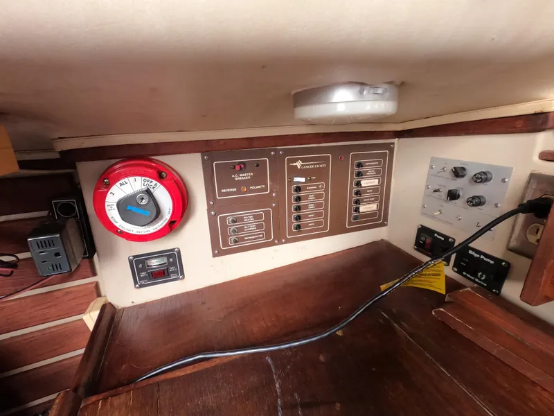 Slide: The Image of 1984 Lancer 30 yacht control panel with switches and timer in wooden interior. - 17