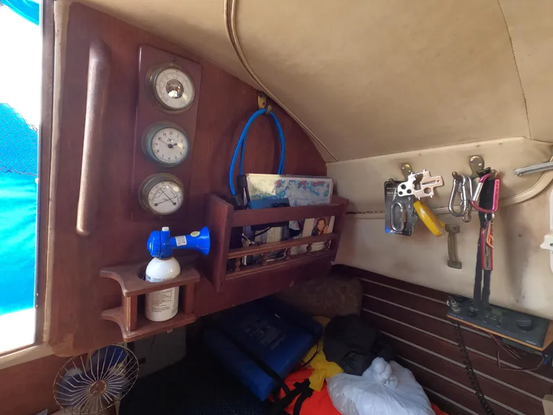 Slide: The Image of Interior of a 1984 Lancer 30 sailboat with gauges, tools, and storage. - 18