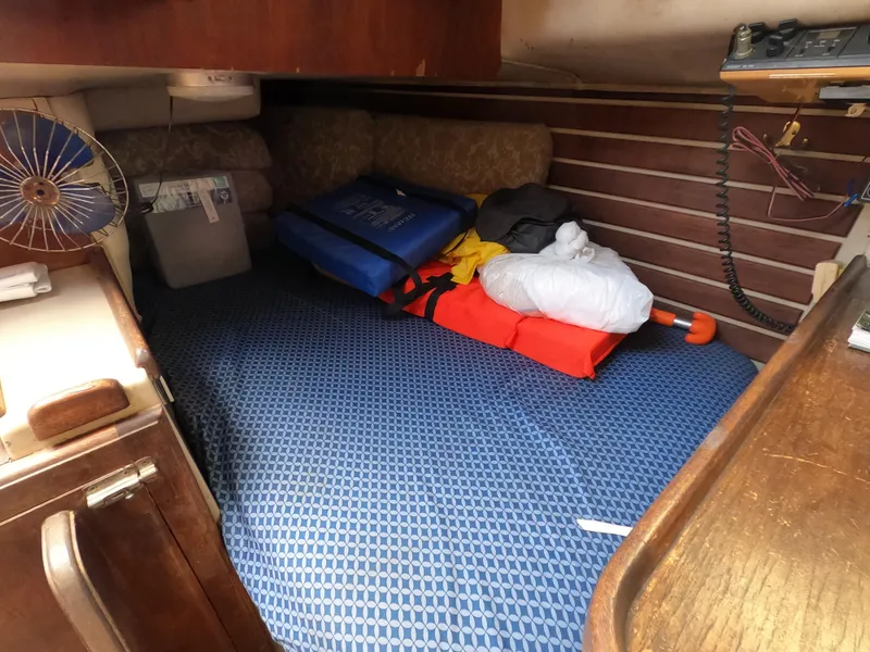 Slide: The Image of Cozy cabin interior of 1984 Lancer 30 sailboat with bedding and storage items. - 19