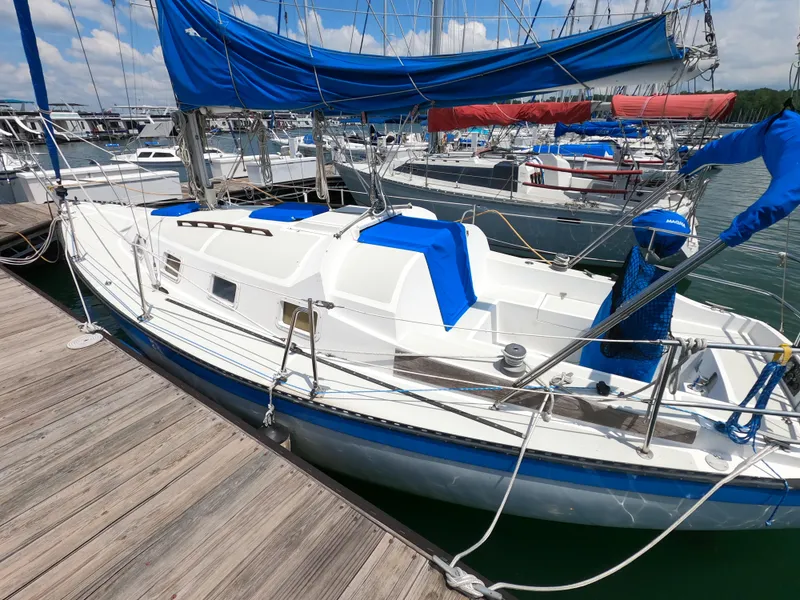 Slide: The Image of 1984 Lancer 30 sailboat docked at marina with blue covers and sails. - 2