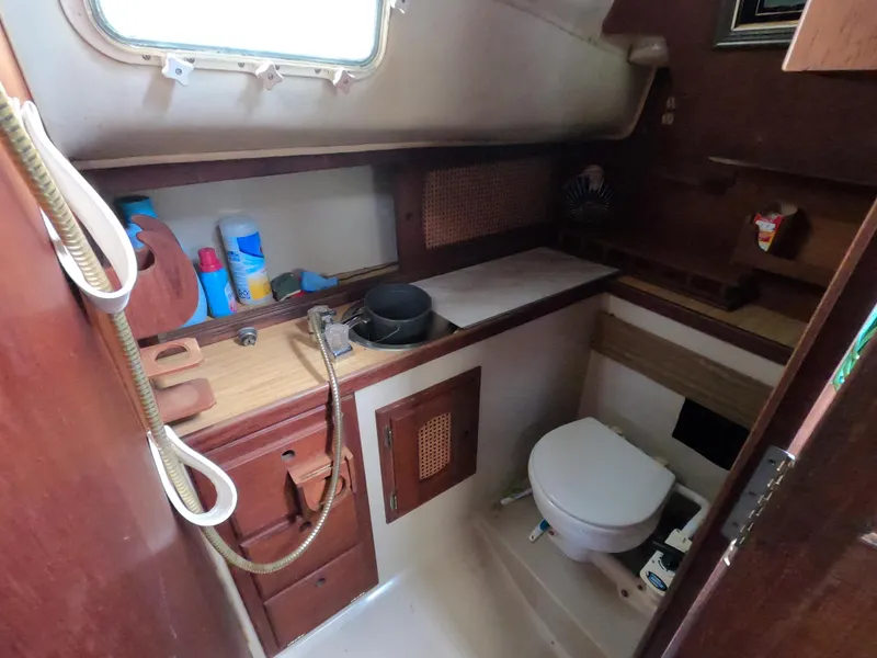 Slide: The Image of 1984 Lancer 30 boat bathroom with wooden cabinetry and compact toilet. - 21