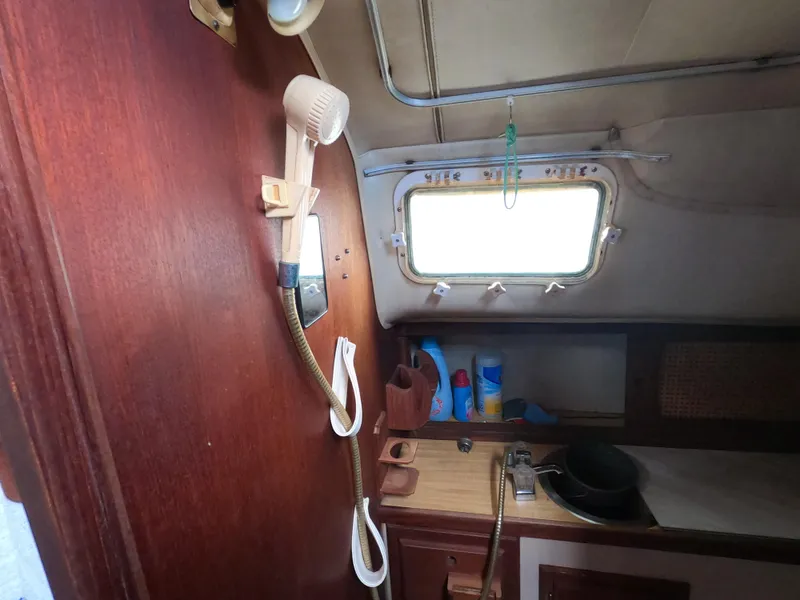 Slide: The Image of Interior of 1984 Lancer 30 sailboat with wooden cabinetry and porthole window. - 22