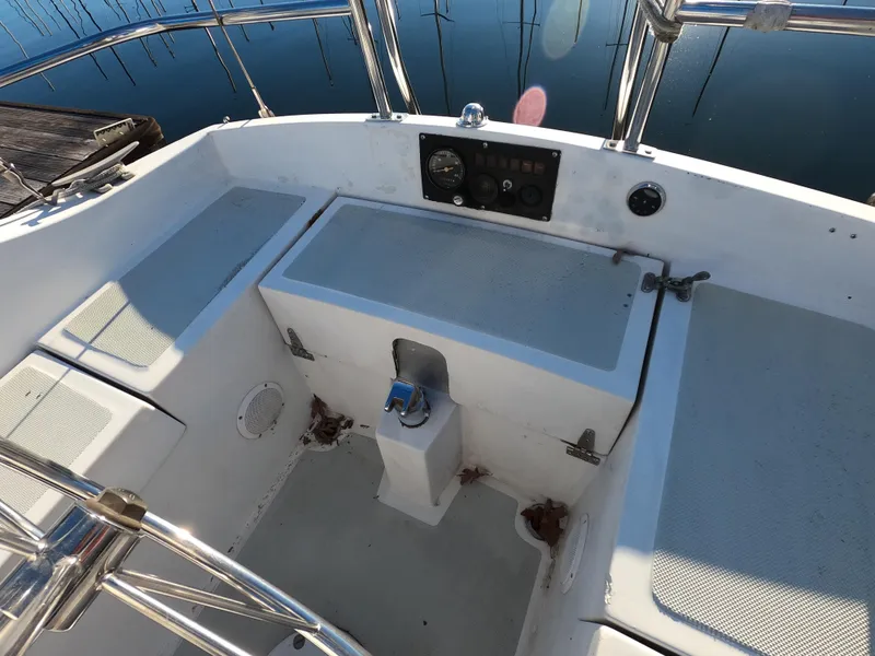 Slide: The Image of 1984 Lancer 30 boat cockpit with seating, steering, and control panel by the water. - 7