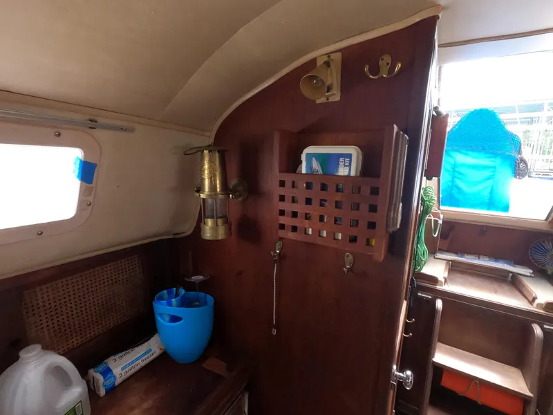 Slide: The Image of Interior of a 1984 Lancer 30 sailboat with wooden cabinetry and nautical decor. - 14