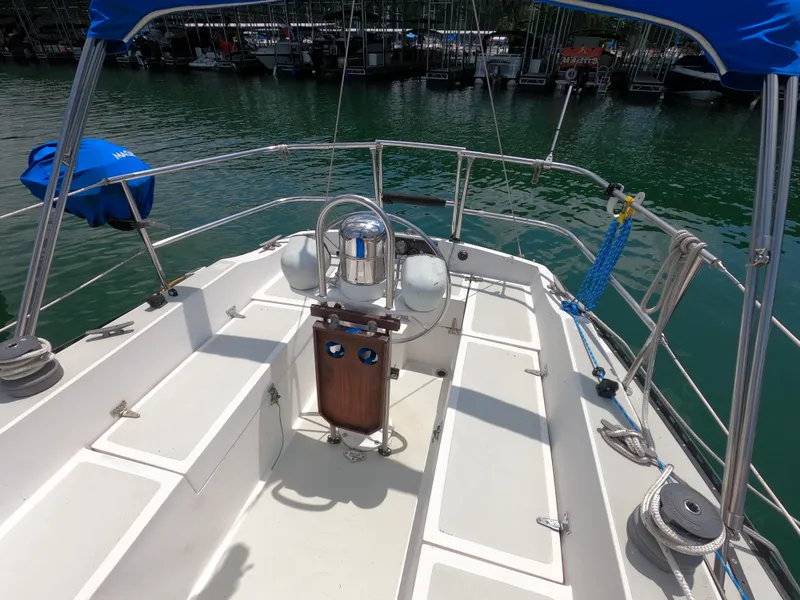 Slide: The Image of 1984 Lancer 30 sailboat cockpit with steering wheel, docked at marina. - 6