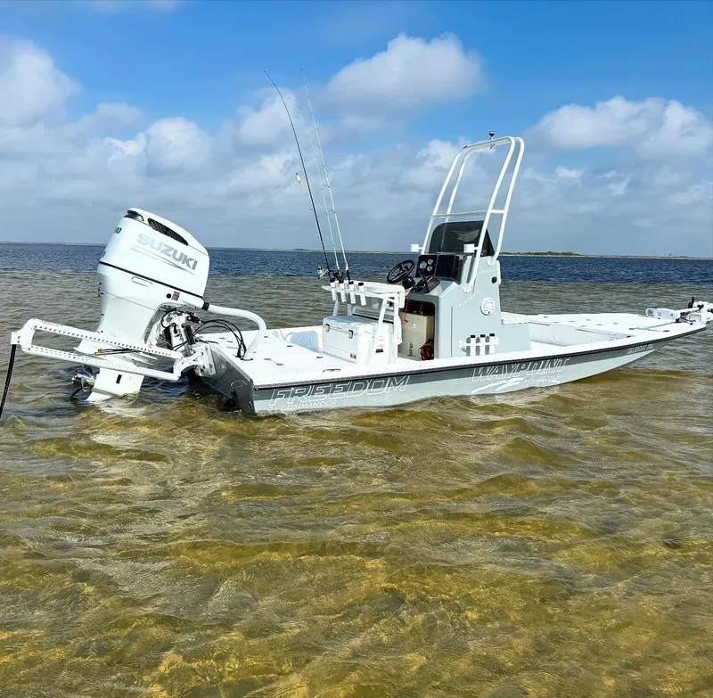 Slide: The Image of 2026 Freedom Boats USA 21' Commander in shallow water, featuring Suzuki outboard motor. - 2