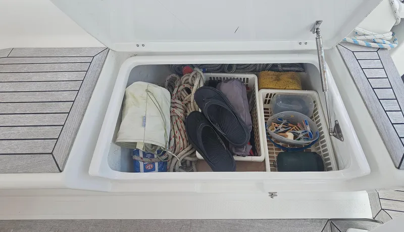 Slide: The Image of Storage compartment on a 2016 Hanse 415 yacht, containing ropes, shoes, and various supplies. - 10