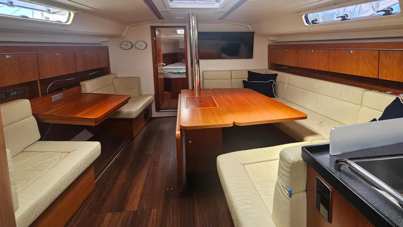 Slide: The Image of Interior of a 2016 Hanse 415 yacht with wooden furnishings and beige seating. - 14