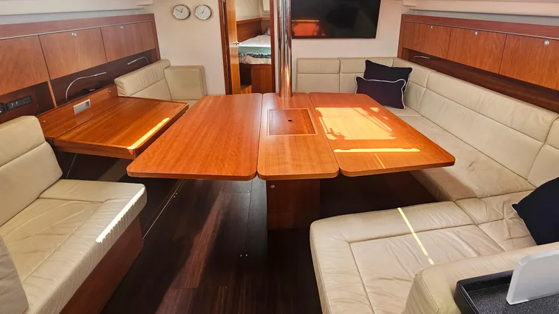 Slide: The Image of Luxurious interior of 2016 Hanse 415 yacht with wooden table and beige seating. - 15