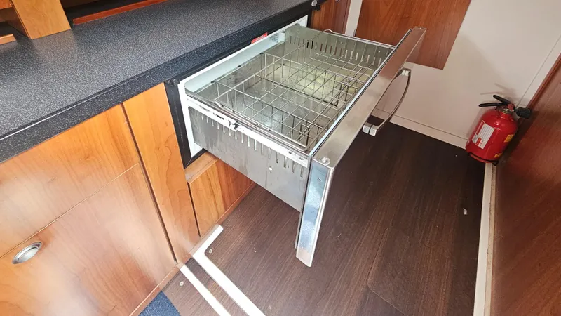 Slide: The Image of Pull-out drawer in 2016 Hanse 415 yacht kitchen with fire extinguisher nearby. - 16
