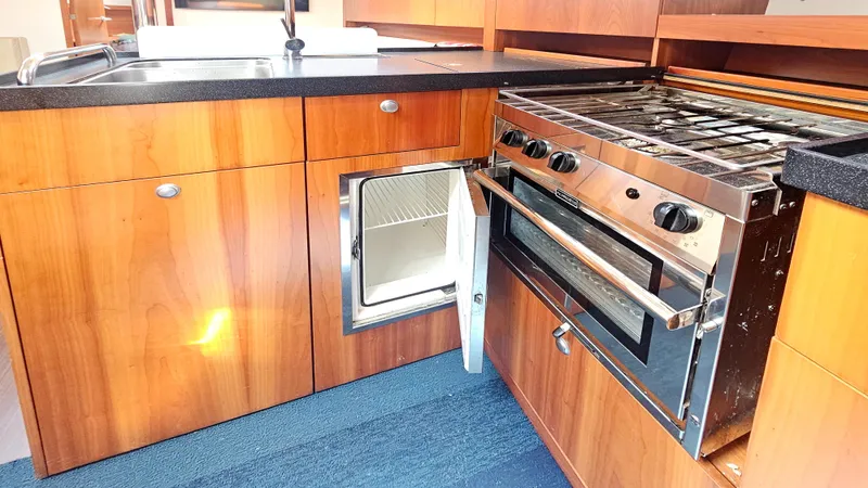 Slide: The Image of Modern kitchen in 2016 Hanse 415 yacht with stove, sink, and open fridge. - 18