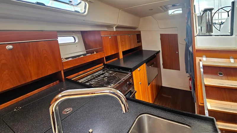 Slide: The Image of Interior of 2016 Hanse 415 yacht kitchen with wooden cabinets and modern appliances. - 19