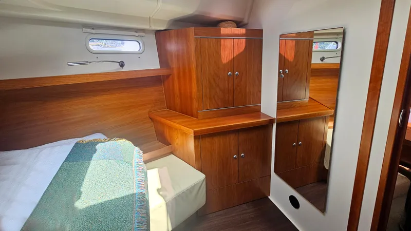 Slide: The Image of Luxurious cabin interior of 2016 Hanse 415 yacht with wooden cabinetry and mirror. - 22