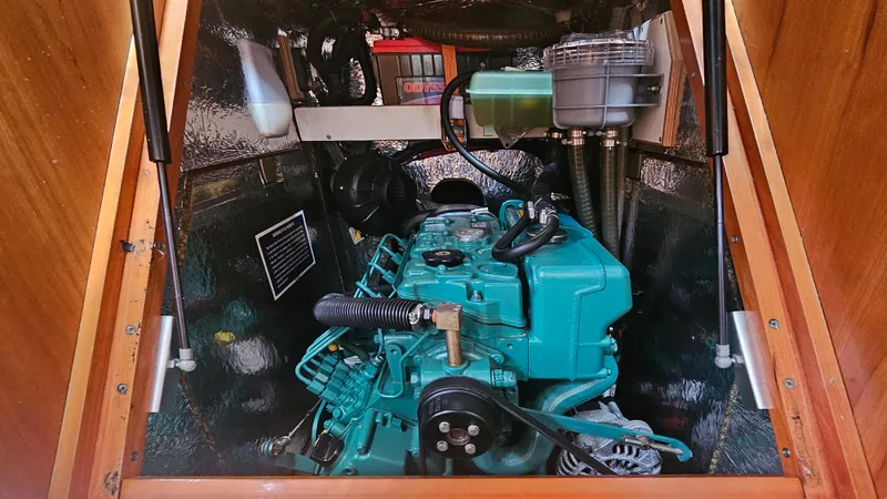 Slide: The Image of Engine compartment of a 2016 Hanse 415 sailboat, featuring a teal marine engine. - 25