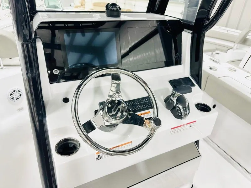 Slide: The Image of 2025 Sportsman Heritage 231 boat dashboard with steering wheel and control panel. - 2