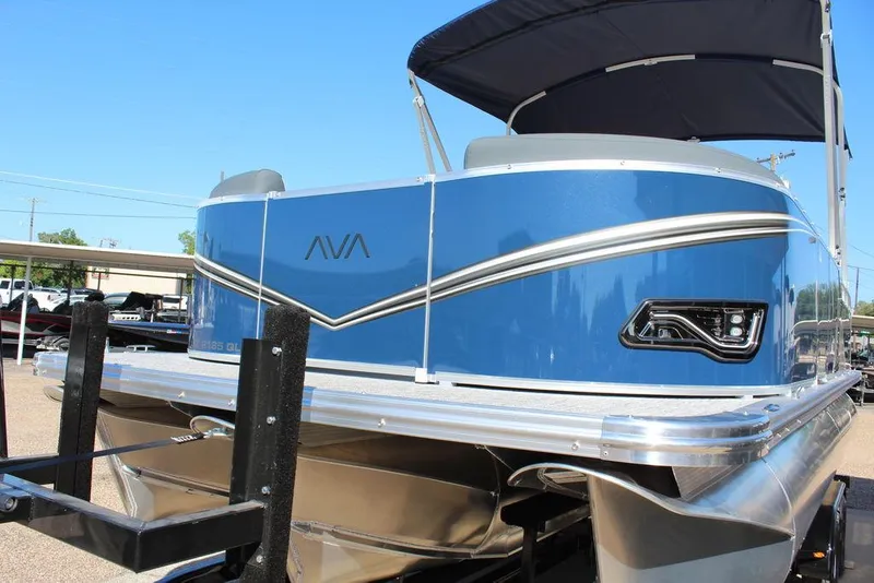 Slide: The Image of 2025 Avalon LSZ Quad Lounger Shift 21 FT pontoon boat, blue exterior, docked on trailer. - 12