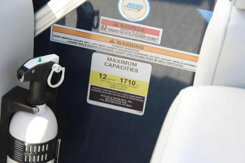 Slide: The Image of 2025 Avalon LSZ Quad Lounger Shift boat capacity warning label and fire extinguisher. - 26