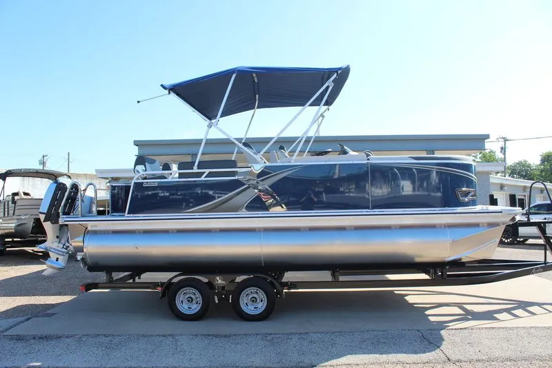 Slide: The Image of 2025 Avalon LSZ Quad Lounger Shift 21 FT pontoon boat with blue canopy on trailer. - 5
