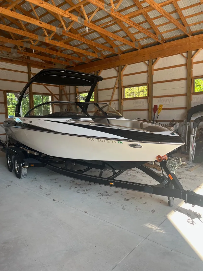 Slide: The Image of 2008 Malibu Sunscape 21 LSV boat in a wooden garage. - 1
