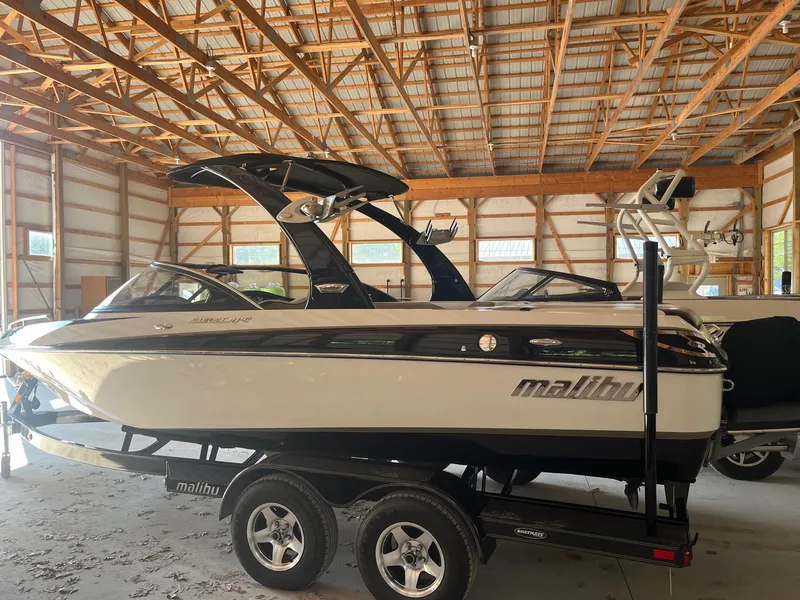 Slide: The Image of 2008 Malibu Sunscape 21 LSV boat in a wooden garage, side view. - 11
