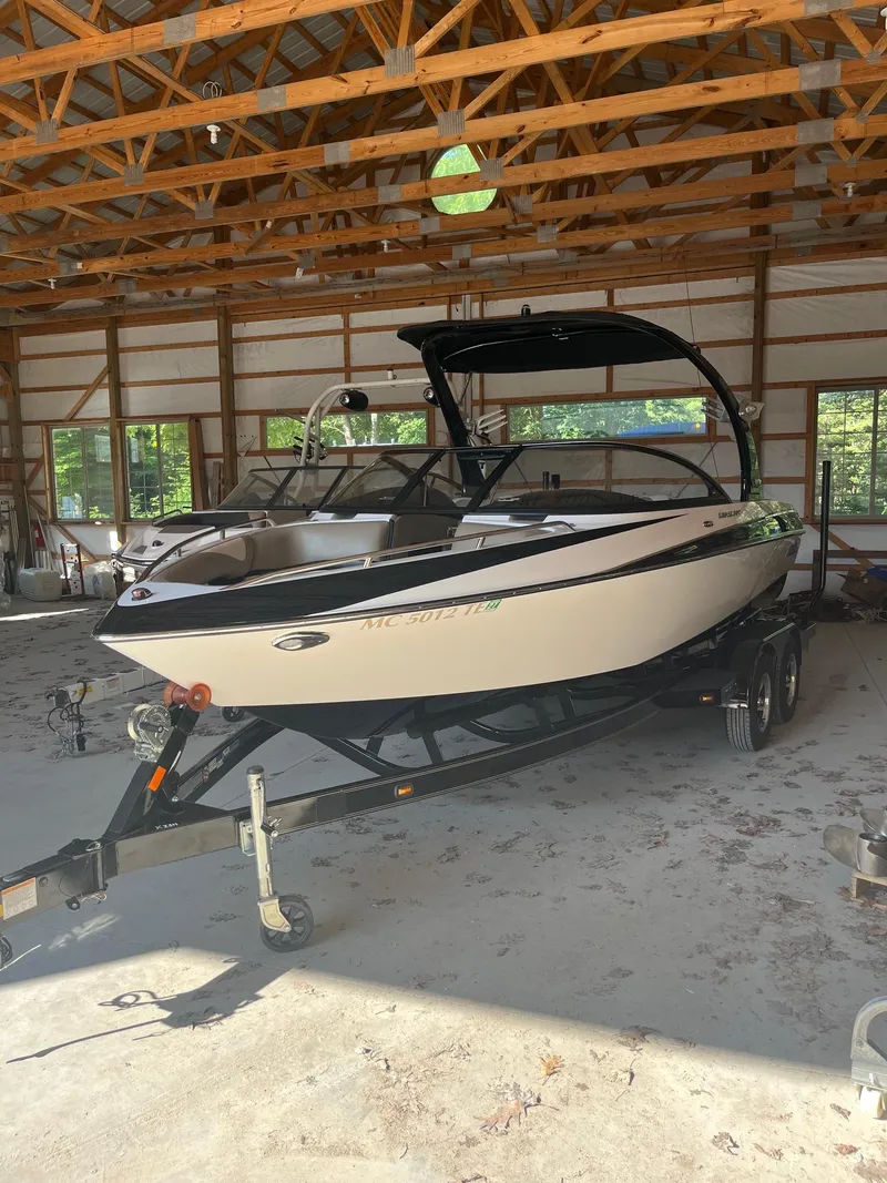Slide: The Image of 2008 Malibu Sunscape 21 LSV boat on trailer inside a wooden garage. - 12