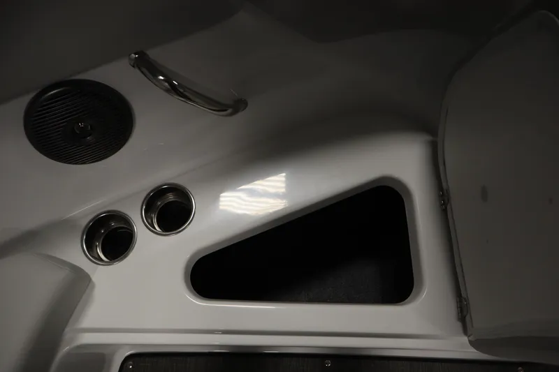 Slide: The Image of Interior detail of 2025 Four Winns H1 Freedom boat, featuring cup holders and storage compartment. - 17