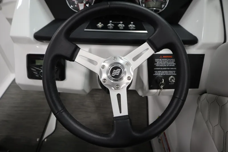 Slide: The Image of 2025 Four Winns H1 Freedom steering wheel, black leather with chrome accents. - 19