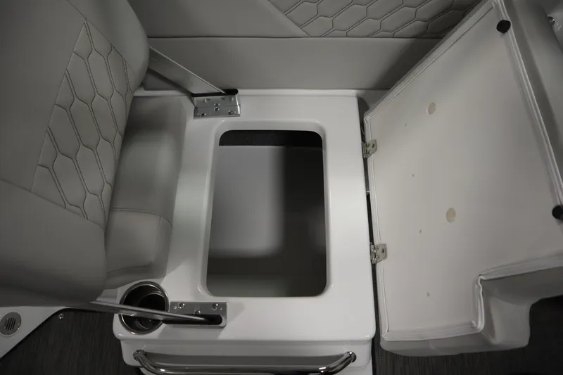 Slide: The Image of 2025 Four Winns H1 Freedom boat interior storage compartment with open lid and cup holder. - 35