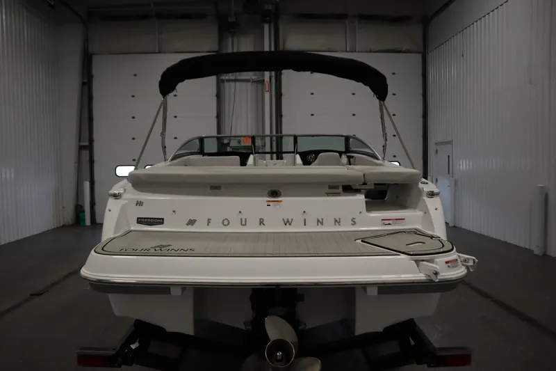 Slide: The Image of 2025 Four Winns H1 Freedom boat in a garage, rear view. - 6