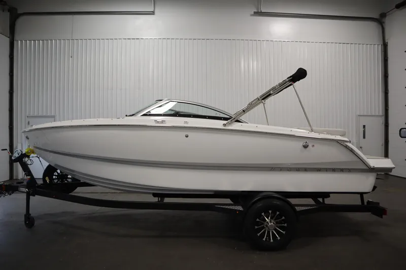 Slide: The Image of 2025 Four Winns H1 Freedom boat on trailer in indoor setting. - 8
