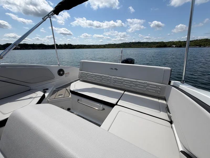 Slide: The Image of The image shows the stern of a Sea Ray SPX 210 Outboard boat on a calm lake. - 27