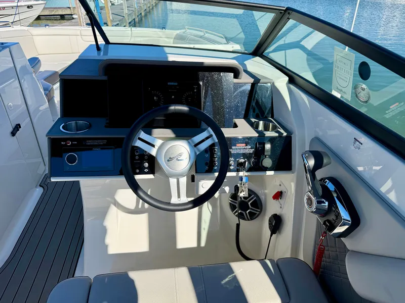 Slide: The Image of The cockpit of the 2026 Sea Ray SDX 290 features a modern steering wheel and controls. - 9
